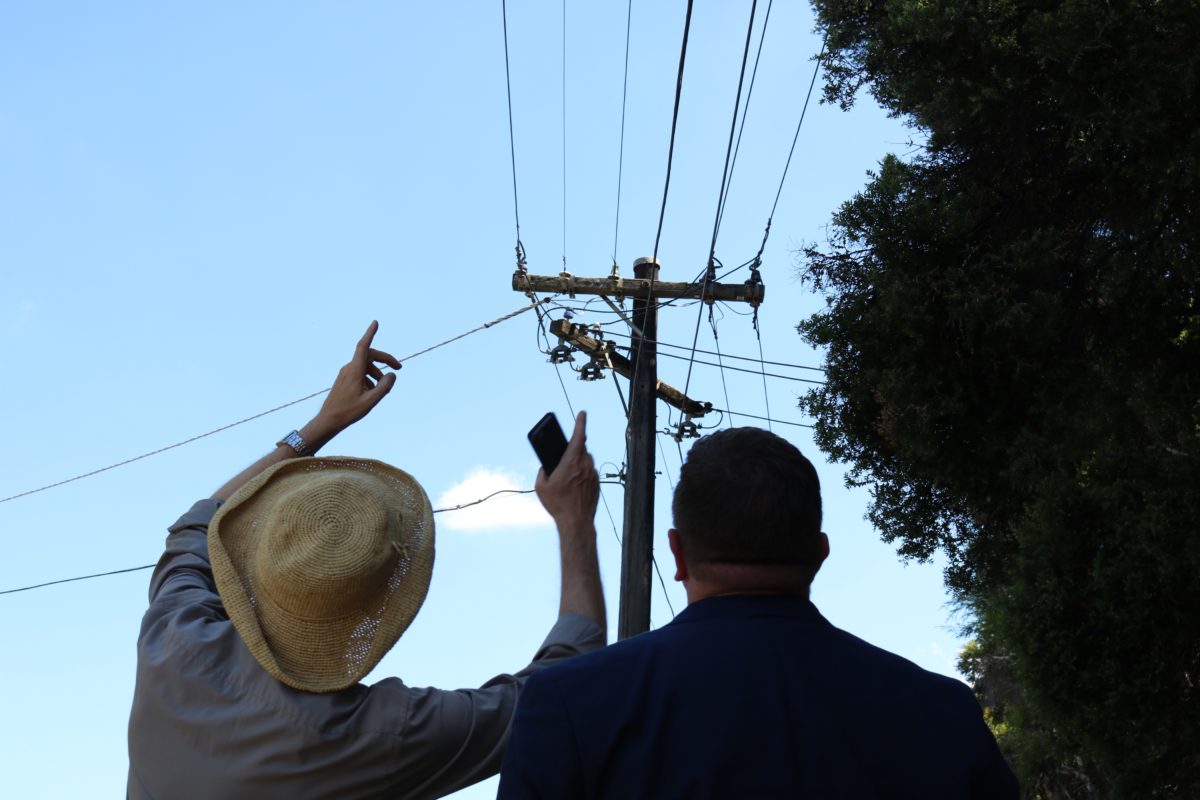 Two people looking up at electricity wires