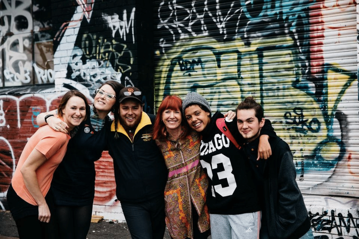 people with arms around each others' shoulders in a Melbourne alley