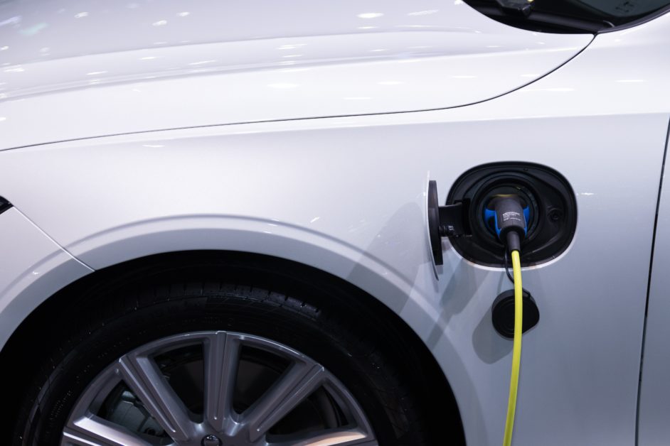 An electric vehicle being plugged in to charge