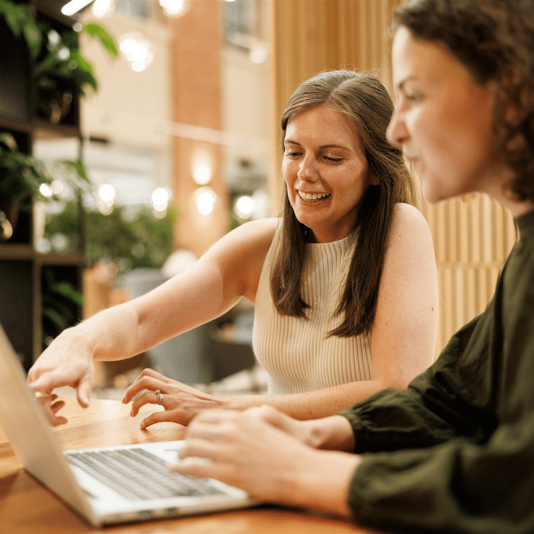 Two people in an office looking at a laptop